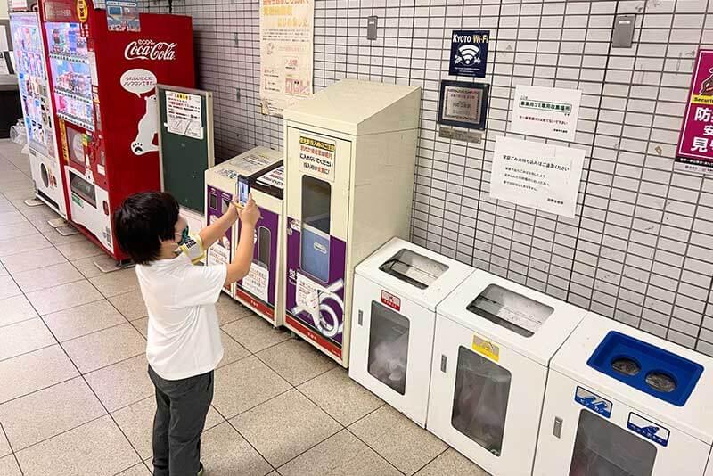 地下鉄にあるプレートをスマホで写す小学生